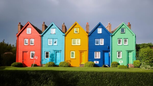 A row of multicoloured housing representative of each of the main UK political parties can be seen.
