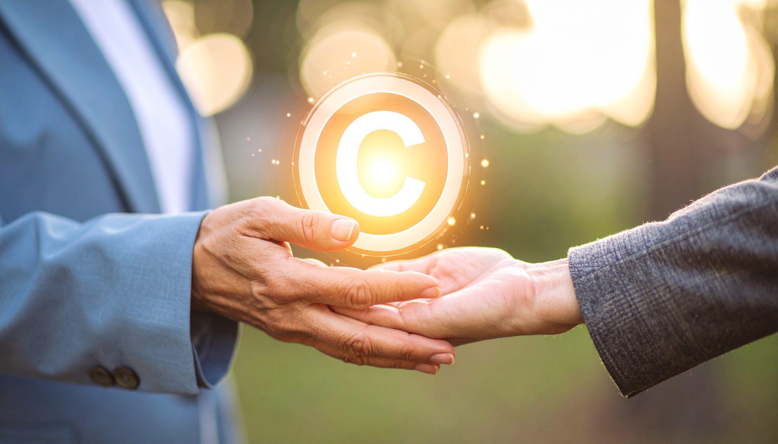 someone passing a glowing copyright symbol to their successor, symbolising how IP assets can be passed down in a Will.